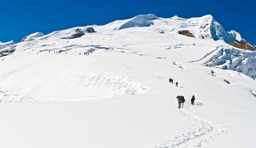 Mountaineers climbing through high altitude snow glacier Mera Peak Climbing Himalayas Nepal